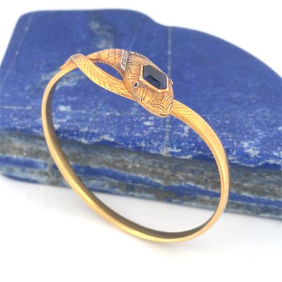 une image représentant une bague en or ornée d'une pierre noire au centre