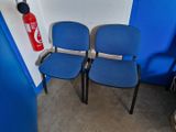 two blue chairs sitting next to each other in a room
