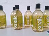 four bottles of liquid sitting on top of a white table