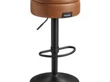 Le tabouret est en cuir et possède un piètement en métal.