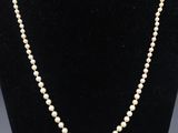 un collier de perles blanches sur un mannequin noir