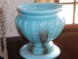 a blue vase sitting on a table in front of a window