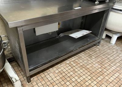 a stainless steel counter in a kitchen with a toilet
