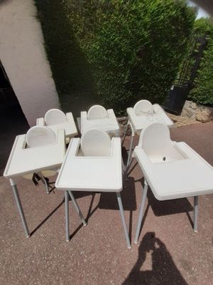 quatre chaises hautes blanches et une chaise haute pour bébé au milieu d'une allée