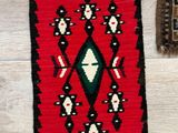 an image of a red and black rug on a wooden floor