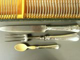 a lot of silverware on a table with a fork and knife