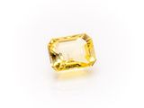 a yellow sapphire stone on a white background