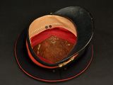a black hat with a red band on top of a black table