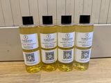 quatre flacons d'huile de bain Turroos posés sur une table