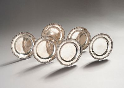 six silver plated dishes are lined up on a white surface