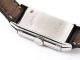 a close up of a watch on a white surface with a brown strap