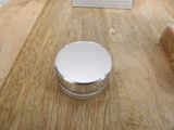 a silver container sitting on a wooden table next to a book
