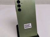 a close up of the back of a green phone with a sticker on it