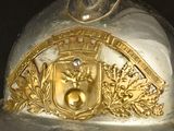 a silver and gold helmet with a crest on it