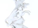 a white figurine of a woman on a horse and a man on a horse