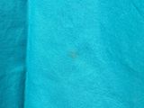 a close up of a blue shirt with a black spot on it
