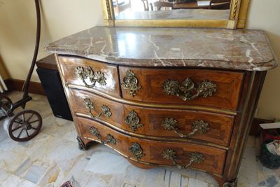 a marble top dresser with a mirror on top of it