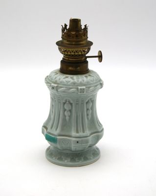 une petite lampe verte posée sur une table blanche