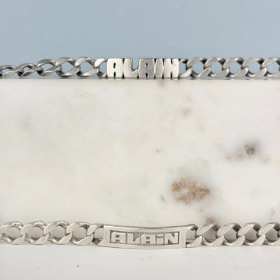 une assiette en argent sur laquelle figure un nom, posée sur une table