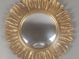 un miroir rond orné d'un motif à la feuille d'or