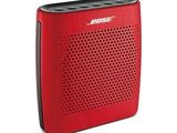 a red bose bluetooth speaker sitting on top of a white surface