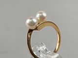 an image of a gold ring with two pearls on top of it