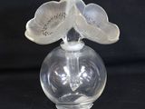 a glass vase with a flower on top of it