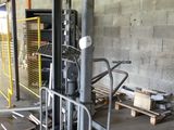 a forklift in the middle of a warehouse with pallets on the floor