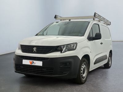 La camionnette blanche est garée dans une pièce au sol noir.