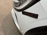 a close up of a white car with a sticker on it ' s hood