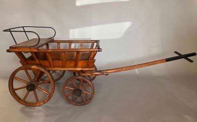 a small wooden wagon with a basket on the back of it