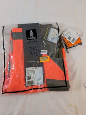 un paquet de vêtements posé sur un lit, muni d'une étiquette