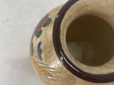 a small vase that is sitting on a white surface