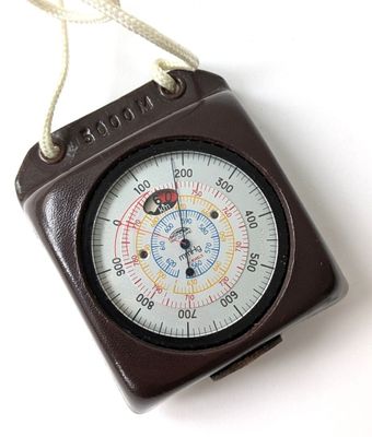 a brown compass with a rope hanging from it ' s side