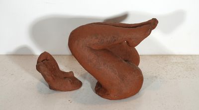 a clay sculpture of a bird and a shoe on a table