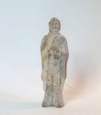 une petite statue représentant un homme debout sur une surface blanche