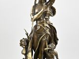 bronze statue of a woman holding a sword and a globe on a stand