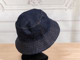 denim bucket hat on display on wooden table in front of white wall
