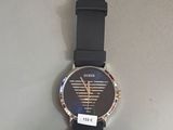 une montre-bracelet munie d'une étiquette, accrochée à un mur