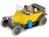 une petite voiture jaune avec un homme et un chien à l'intérieur