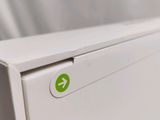 a close up of a white refrigerator with a green arrow on it