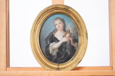 un tableau représentant une femme tenant un oiseau, dans un cadre doré