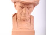 a clay bust of a man with a hat on