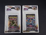Deux paquets de cartes à collectionner Pokémon sont posés sur une surface noire.
