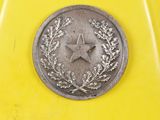 a close up of a coin with a star on it on a yellow surface
