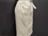 a white dress on a mannequin stand against a gray wall