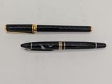 deux stylos à plume noirs et dorés posés sur une surface blanche