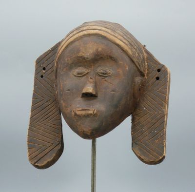 Masque d’applique en bois léger à patine sombre figurant un …