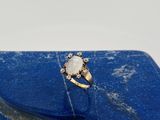 un gros plan d'une bague posée sur une pierre bleue
