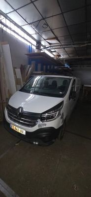 La camionnette blanche est garée dans le garage de l'immeuble.
